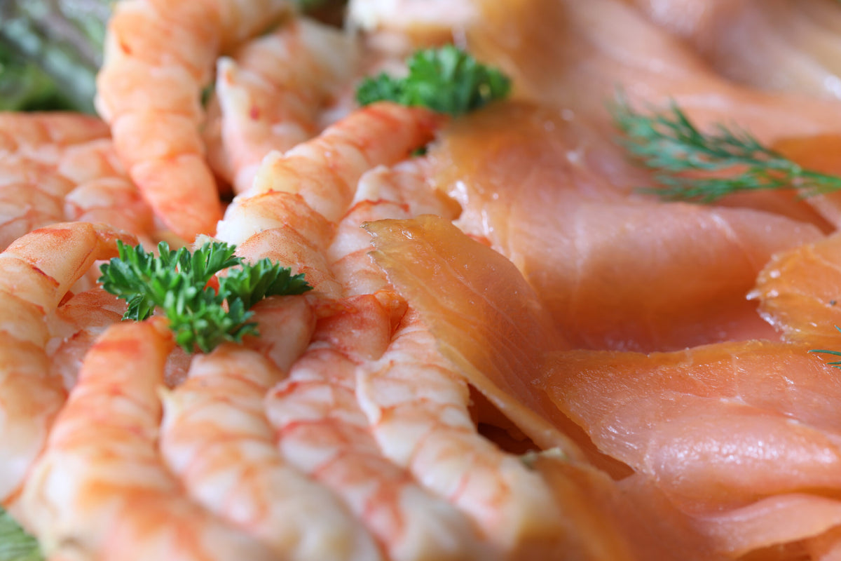 Fischplatte Vom Feinsten, Nahaufnahme mit Räucherlachs-Röllchen und Dill