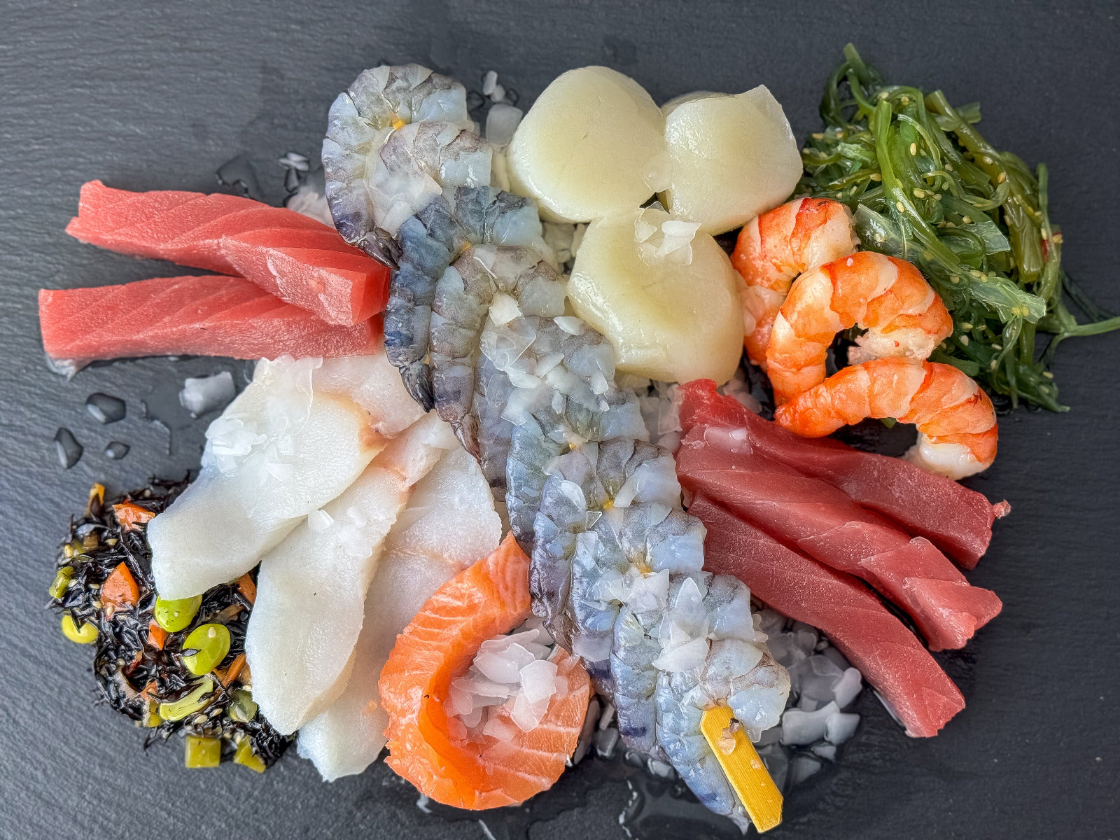 Frische Fisch- und Meeresfrüchte-Auswahl der Wuppertaler Fischkultur auf Schiefer: Thunfisch, Lachs, Jakobsmuscheln, Garnelen, weißer Fisch und Algensalat