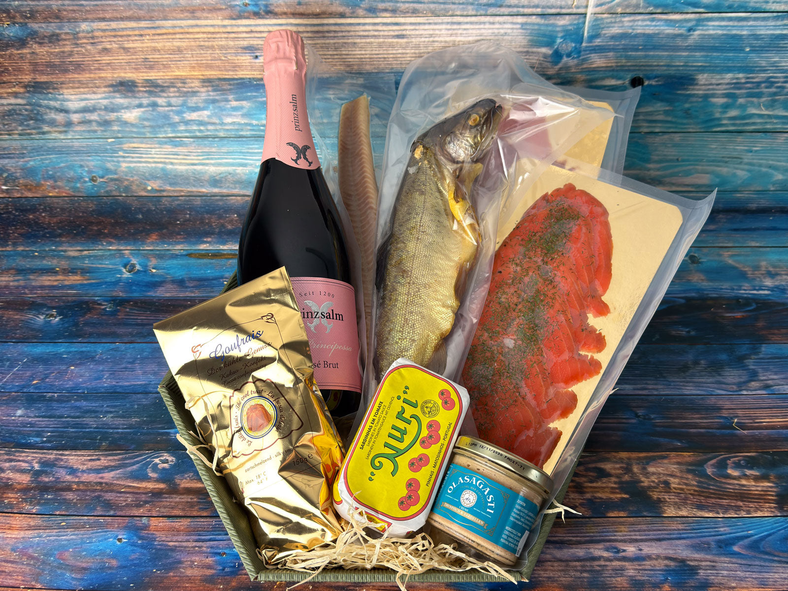 Präsentkorb der Wuppertaler Fischkultur mit Rosé-Sekt, heißgeräucherter Forelle, Graved Lachs, Aalfilet, Sardinen, Thunfischcreme und Konfekt
