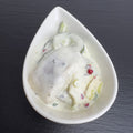 Herings-Happen mit Zitronen-Minze in weißer Schale auf schwarzem Schiefer: Hering mit Gurke und Apfel in cremigem Dressing.