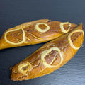 Zwei heißgeräucherte Makrelenfilets mit goldbrauner Haut und weichen Zwiebelringen auf dunkler Schieferplatte.