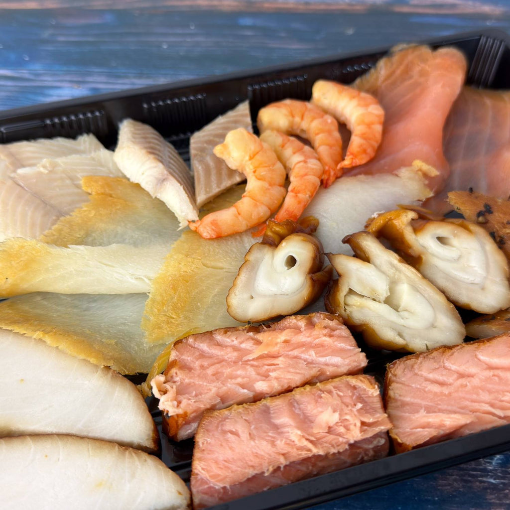 Räucherfisch-Variation XL in Nahaufnahme: Garnelen, Räucherlachs, Schillerlocken, Heilbutt, heißgeräucherter Lachs und weitere Sorten aus unserer Räucherei.