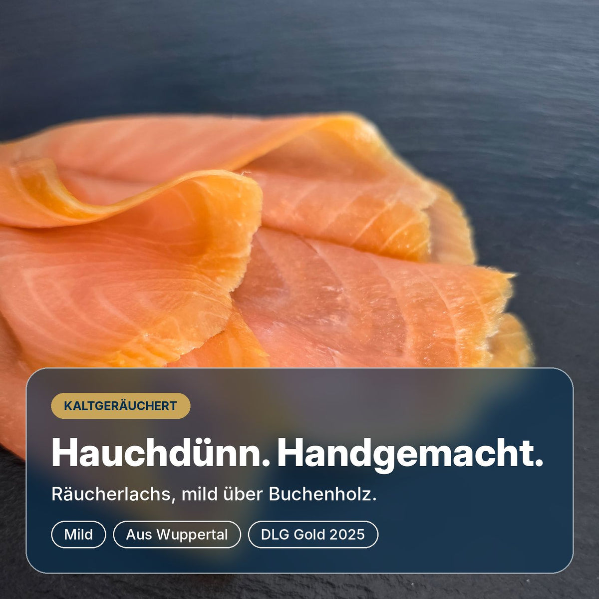 Hauchdünn und handgemacht: Räucherlachs Classic aus Wuppertal auf Schiefer, mild über Buchenholz kaltgeräuchert und mit DLG-Gold 2025 ausgezeichnet.