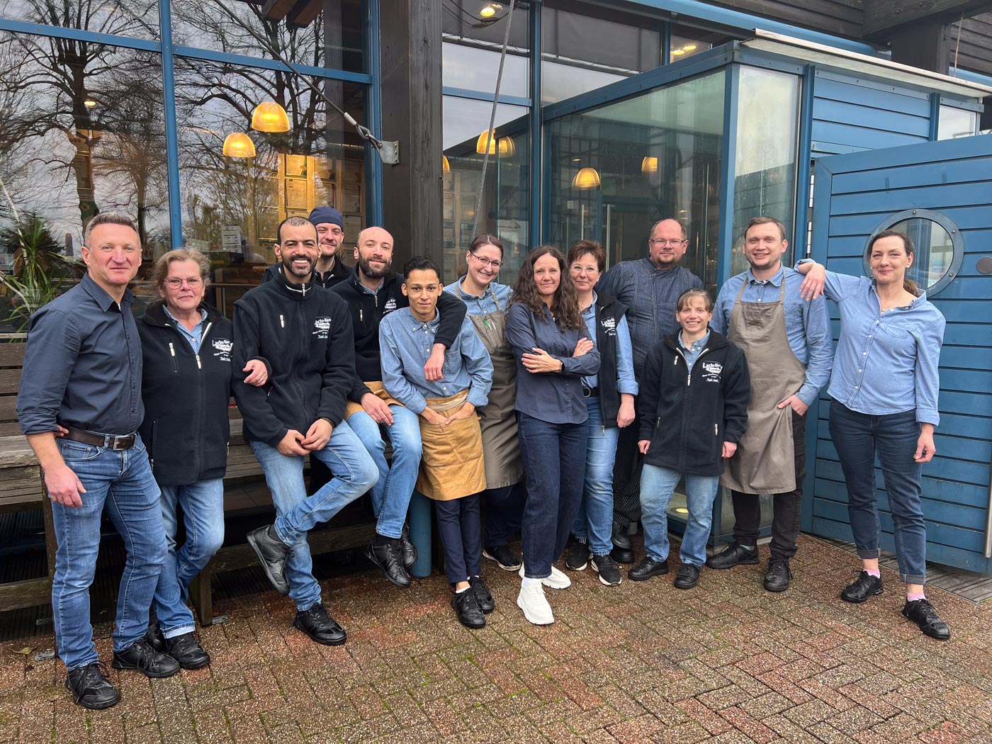 Das Team der Wuppertaler Fischkultur aus Theke, Küche und Service gut gelaunt vor dem Haus in der Schmiedestraße in Wuppertal