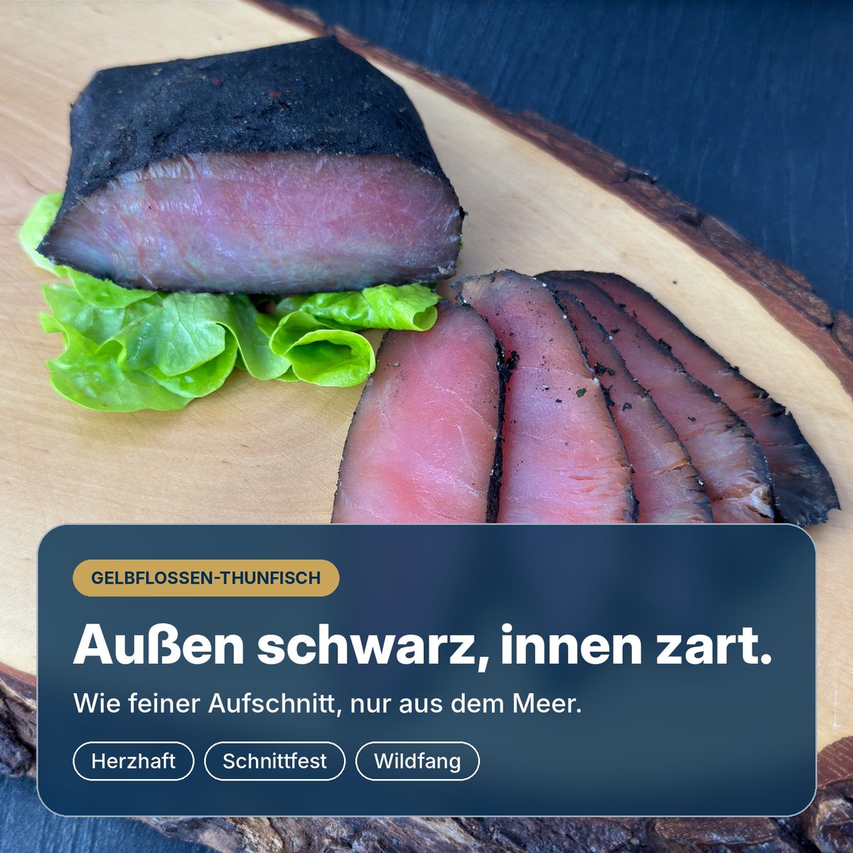 Außen schwarz, innen zart: kaltgeräuchertes Gelbflossen-Thunfischfilet Black Edition, herzhaft gewürzt und schnittfest, in Scheiben auf einem Holzbrett.