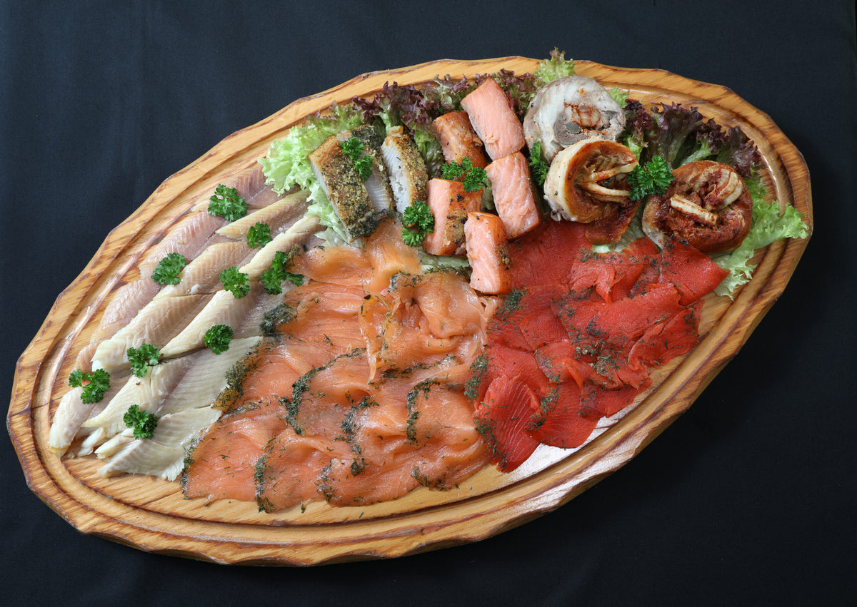 Würziges Spezialitätenbrett der Wuppertaler Fischkultur, angerichtet auf ovaler Platte mit Räucherlachs und Räucherfisch
